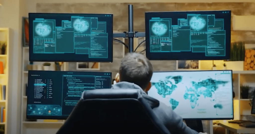A hacker looking at several monitors A hacker looking at several monitors